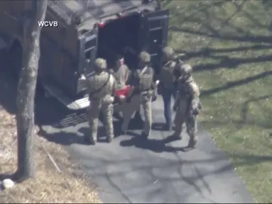 Jack Teixeira, dengan kaus dan celana pendek, ditahan oleh agen taktis bersenjata pada Kamis, 13 April 2023, di Dighton, Mass. (WCVB-TV via AP)