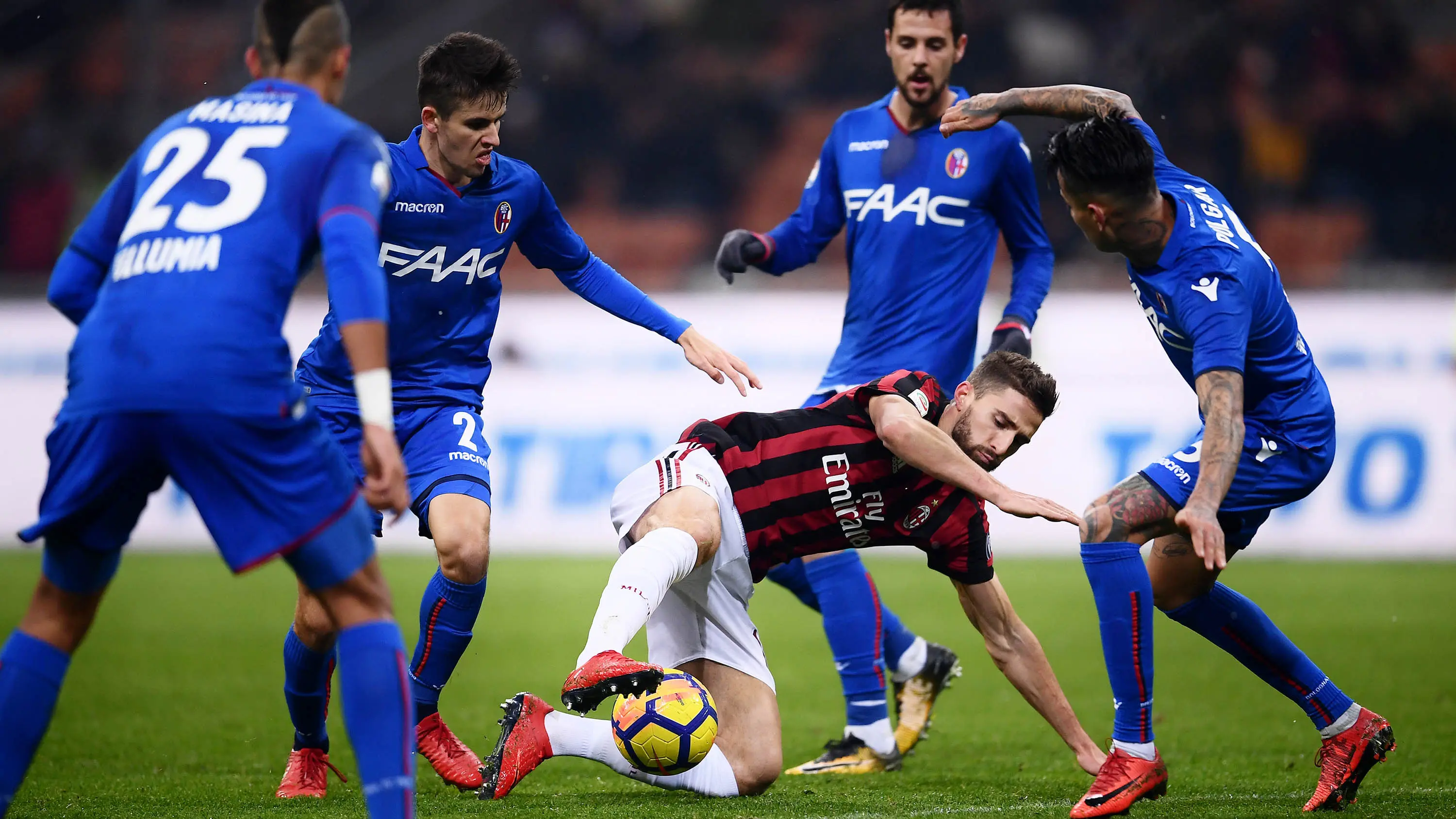 Striker AC Milan, Fabio Borini, berusaha melewati para pemain Bologna pada laga Serie A di Stadion San Siro, Senin (11/12/2017). AC Milan menang 2-1 atas Bologna. (AFP/Marco Bertorello)