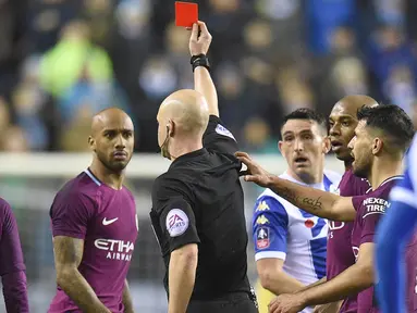 Wasit Anthony Taylor memberikan kartu merah kepada pemain Manchester City. Fabian Delph (2kiri) pada laga babak kelima Piala FA di DW Stadium, Wigan, (19/2/2018). Manchester City kalah 0-1. (AFP/Oli Scarff)