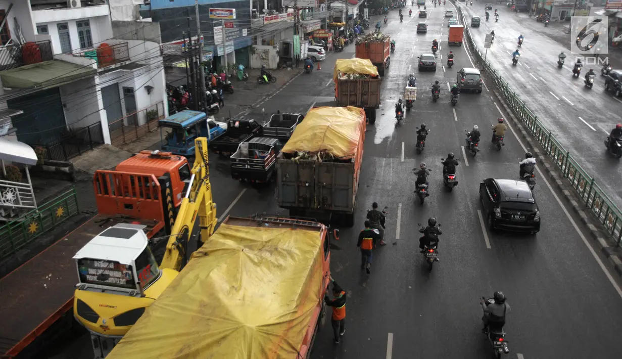 Truk-truk mengangkut sampah yang menumpuk di Jembatan Jalan KH Abdullah Syafei, Jakarta, Selasa (6/2). Puluhan truk sampah dikerahkan petugas untuk mengangkut sampah tersebut. (Liputan6.com/Arya Manggala)