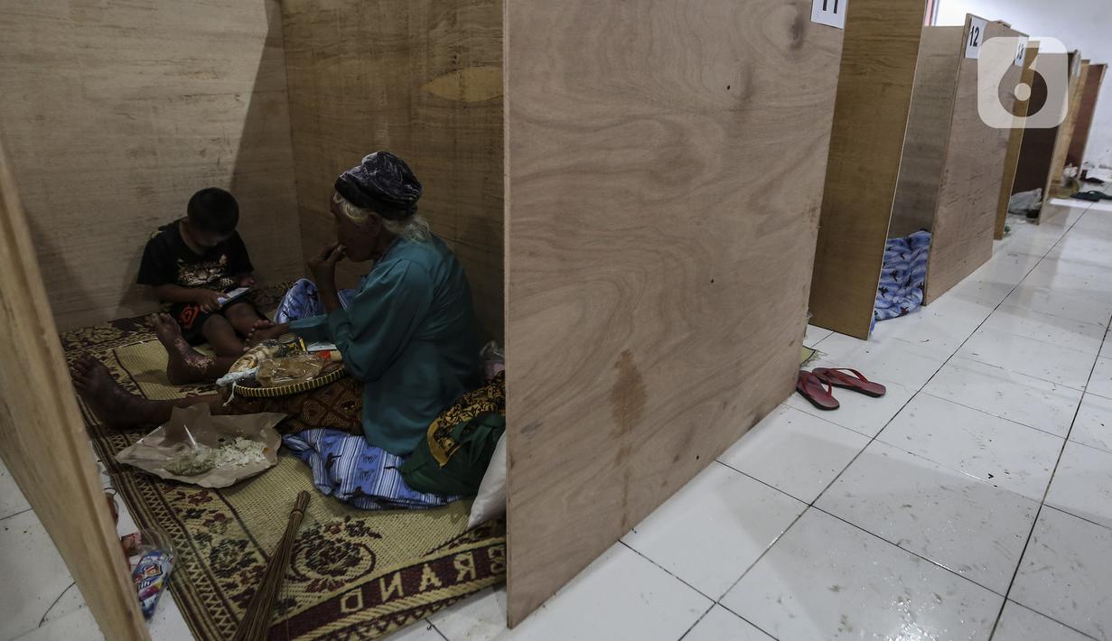Pengungsi Gunung Merapi makan dalam bilik lokasi pengungsian di Desa Glagaharjo, Sleman, Jawa Tengah, Rabu (18/11/2020). Kondisi Gunung Merapi yang memasuki level siaga membuat beberapa desa dengan radius 5 Km dari puncak Gunung Merapi mengungsikan penduduknya. (Liputan6.com/Johan Tallo)