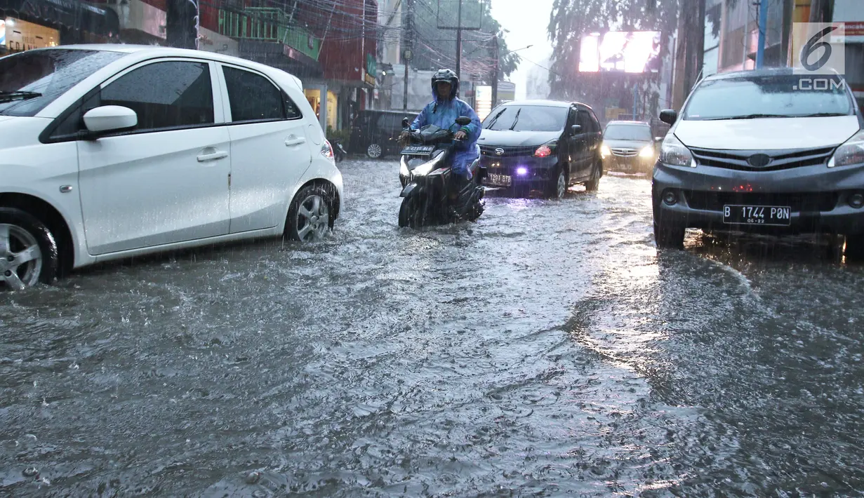Sejumlah kendaraan menerobos genangan air di kawasan Kemang, Jakarta Selatan, Kamis (18/10). Akibat hujan deras, kawasan di Jalan Kemang kembali tergenang air. (Liputan6.com/Herman Zakharia)