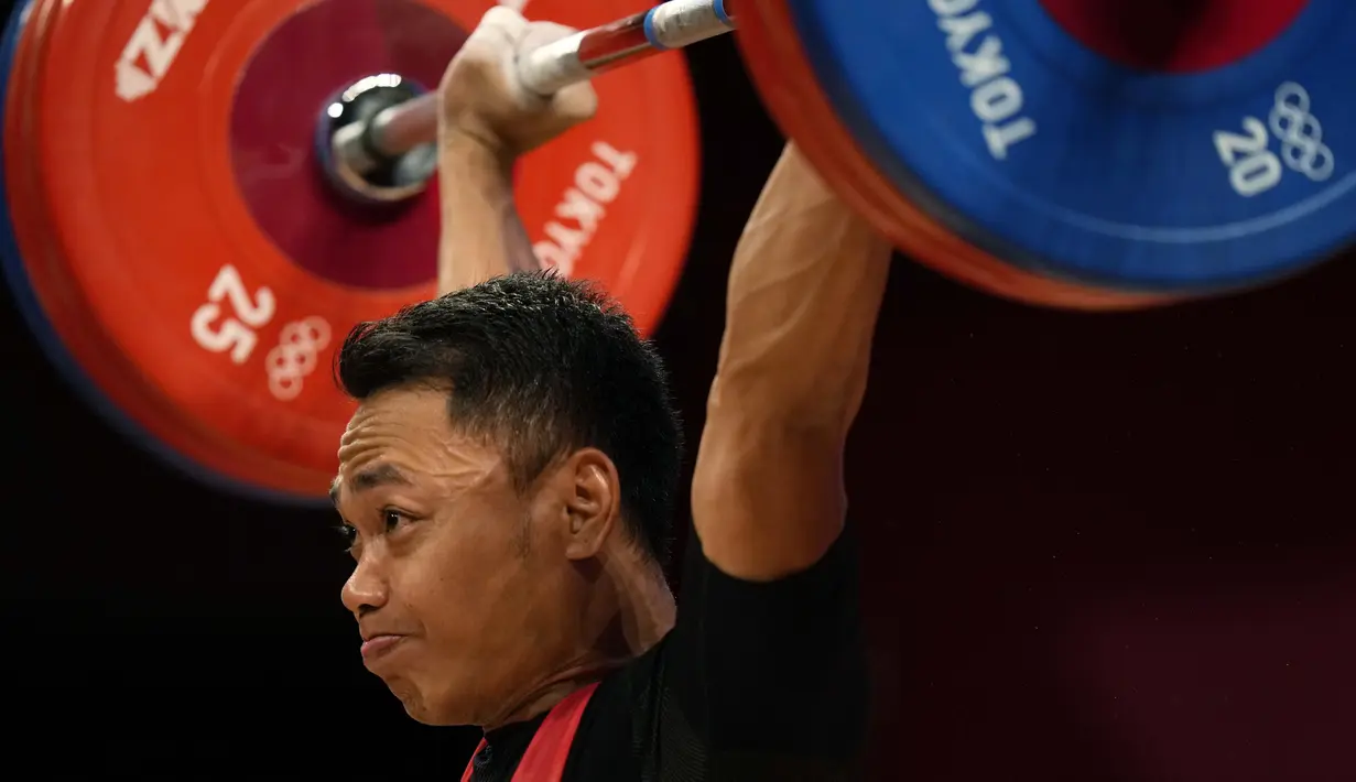 Lifter andalan Indonesia, Eko Yuli Irawan bertanding dalam kelas 61kg putra Grup A cabor angkat besi Olimpiade Tokyo 2020 di Tokyo International Forum, Minggu (25/7/2021). Eko Yuli meraih medali perak dengan total angkatan 302 kg. (AP Photo/Luca Bruno)