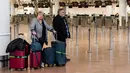 Dua penumpang menunggu informasi ketika mereka berada di Bandara Brussels, Zaventem, Belgia, Rabu (13/2). Penutupan lalu lintas udara Belgia dimulai sejak Selasa 12 Februari 2019 pukul 22.00 waktu setempat. (AP Photo/Geert Vanden Wijngaert)