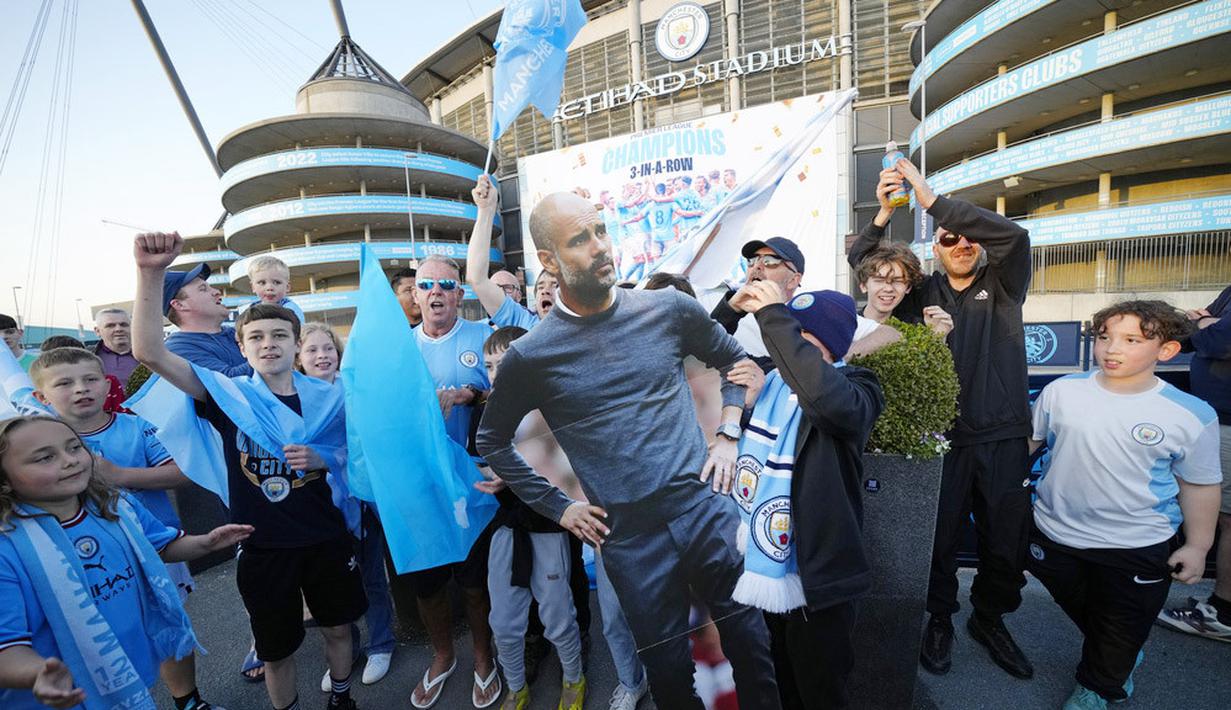 Sejumlah suporter Manchester City merayakan gelar juara Liga Inggris di depan Stadion Etihad, Sabtu (20/5/2023). City memastikan gelar juara setelah Arsenal dikalahkan Nottingham Forest dengan skor 0-1 pada lanjutan Liga Inggris 2022/2023 hari Minggu (21/05/2023). (AP Photo/Jon Super)