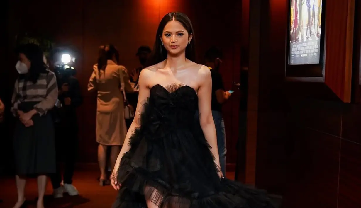 Dalam beberapa potret yang beredar diunggah di laman Instagram pribadinya, Maudy tampak mengenakan dress hitam dengan potongan yang pas di tubuhnya. Detail pada gaun tersebut semakin menonjolkan siluetnya yang menawan. Calon saudara ipar Fuji ini memadukan tampilannya dengan riasan yang natural serta aksesoris minimalis yang semakin menambah kesan elegan. (Liputan6.com/IG/@maudyeffrosina)