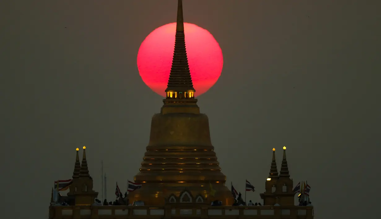 Matahari terbenam di belakang Kuil Wat Saket, atau Gunung Emas di Bangkok, Thailand (11/3). (Reuters/Athit Perawongmetha)