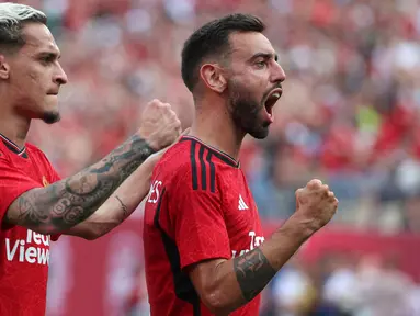 Manchester United terus menjaga hasil sempurna dalam laga pramusim 2023/2024 dengan sapu bersih tiga kemenangan. Kemenangan terakhir MU diraih atas Arsenal dengan skor 2-0 yang dilengkapi dengan kemenangan adu penalti 5-3 di MetLife Stadium, New Jersey, USA, Minggu (23/7/2023) pagi WIB. Sesuai regulasi penyelenggara, pertandingan dilanjutkan dengan babak adu penalti apapun hasil yang didapat pada laga normal. Dua gol kemenangan Setan Merah dicetak Bruno Fernandes pada menit ke-30 dan Jadon Sancho tujuh menit kemudian. Di babak adu penalti, semua penendang MU mampu mencetak gol, sementara satu penendang Arsenal gagal. (AFP/Getty Images/Al Bello)