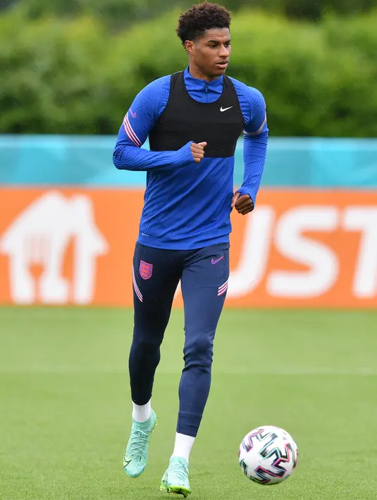Penyerang Inggris, Marcus Rashford membawa bola saat mengikuti sesi latihan di Tottenham Hotspur training di London (21/6/2021). Inggris akan bertanding melawan Republik Ceko pada grup D Euro 2020 di Stadion Wembley. (AFP/Justin Tallis)