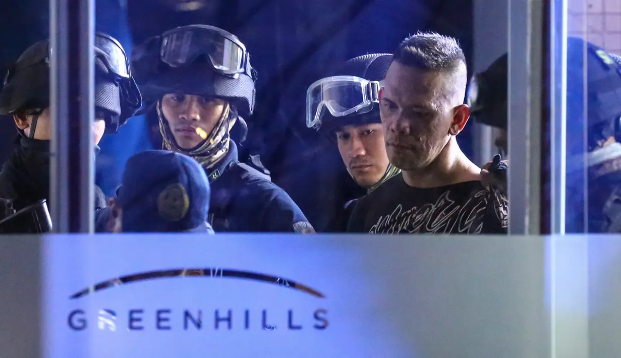 Pelaku penyenderaan Alchie Paray (kanan) digelandang petugas setelah ditangkap di V-Mall, Manila, Filipina, Senin (2/3/2020). Salah seorang pimpinan Paray ketika dia masih menjadi penjaga mal mengaku menyesal telah memecatnya. (AP Photo/Gerard Carreon)
