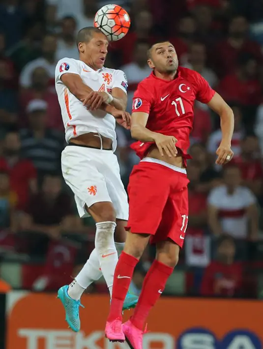 Bek Belanda, Jeffry Bruma (kiri) berebut bola udara dengan penyerang Turki, Burak Yilmaz pada kualifikasi Grup A Euro 2016 di Konya, Turki, (6/9/2015). Turki menang atas Belanda dengan skor 3-0. (AFP PHOTO/Stringer)