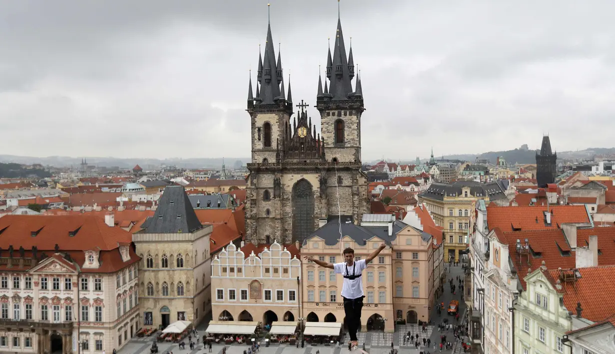 Atlet menyeimbangkan tubuhnya saat berjalan di atas tali yang membentang di Old Town Square, Praha, Republik Ceko, (25/9). Pertunjukan tersebut merupakan bagian kampanye dukungan orang-orang yang hidup dengan diabetes. (AP Photo/Petr David Josek)