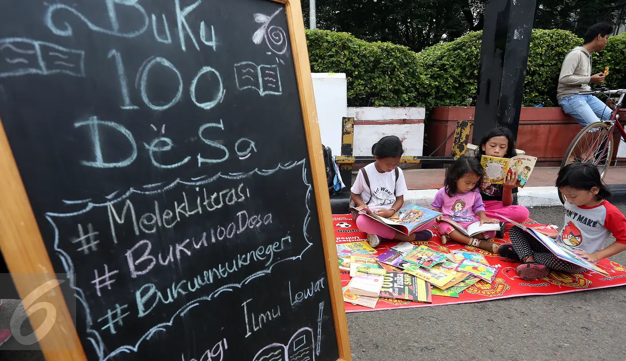 Sejumlah anak membaca buku di Kawasan Bundaran HI saat berlangsungnya Hari Bebas Kendaraan Bermotor, Jakarta, Minggu (2/4). Kegiatan ini dilakukan sebagai ajakan kampanye "Budayakan Membaca dari Desa untuk Indonesia". (Liputan6.com/Johan Tallo)
