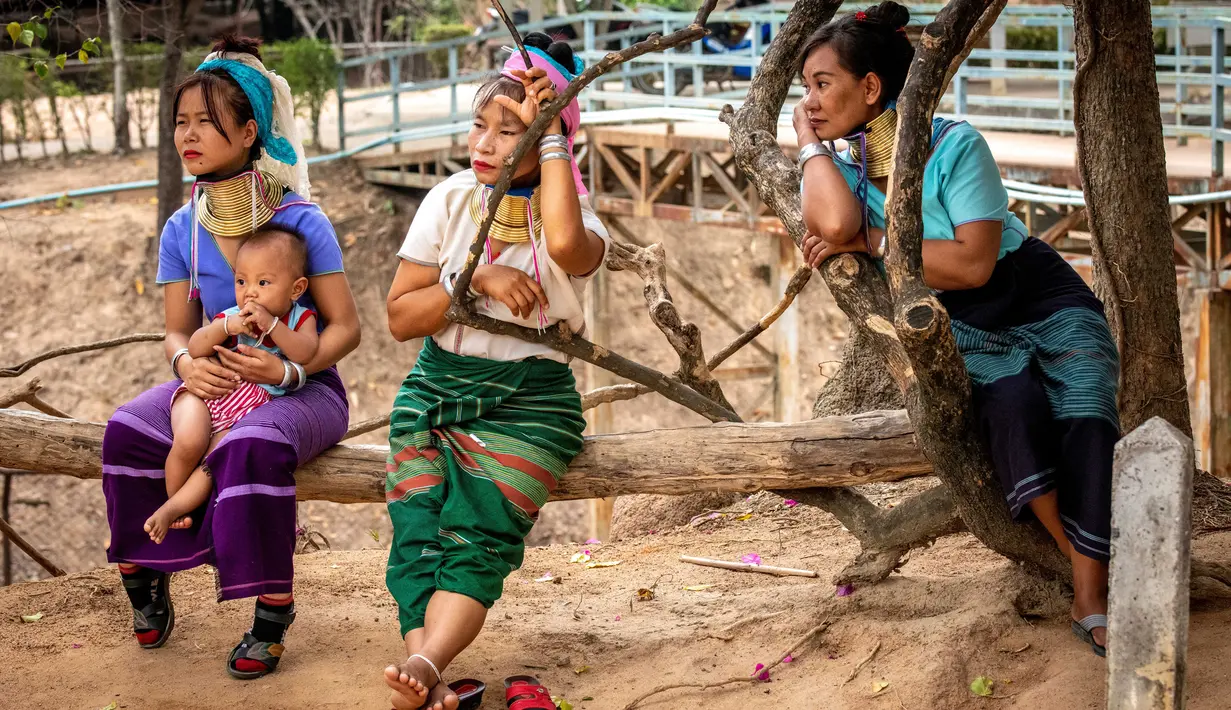 Perempuan Suku Kayan menunggu turis di luar kios suvenir mereka di Taman Chang Siam, Pattaya, Thailand, Rabu (12/2/2020). Chang Siam Park adalah salah satu primadona bagi wisatawan China di Pattaya  yang kini berangsur sepi karena penyebaran virus corona covid-19. (Mladen ANTONOV / AFP)