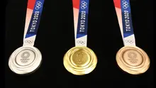 Medali Olimpiade Tokyo 2020 resmi diumumkan kepada publik saat seremoni untuk merayakan momen satu tahun jelang Olimpiade di Tokyo, Rabu (24/7/2019). Medali yang didesain Junichi Kawanishi itu berdiameter 85 mm dan dihiasi gambar dewi Yunani, Nike serta logo Olimpiade. (Behrouz MEHRI/AFP)