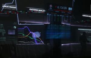 Pekerja tengah melintas di layar pergerakan IHSG di Bursa Efek Indonesia, Jakarta, Senin (18/11/2019). Indeks Harga Saham Gabungan (IHSG) ditutup pada zona merah pada perdagangan saham awal pekan ini IHSG ditutup melemah 5,72 poin atau 0,09 persen ke posisi 6.122,62. (Liputan6.com/Angga Yuniar)