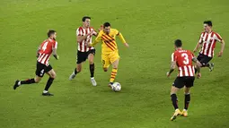 Pemain Barcelona Lionel Messi (tengah) menggiring bola melewati empat pemain Athletic Bilbao pada pertandingan Liga Spanyol di Stadion San Mames, Bilbao, Spanyol, Rabu (6/1/2021).Barcelona menang 3-2 dengan dua gol dari Lionel Messi. (AP Photo/Alvaro Barrientos)
