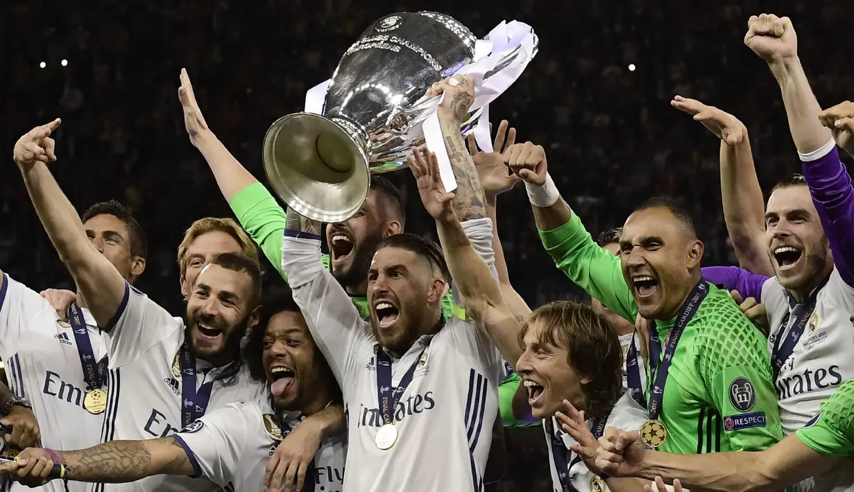 Kapten Real Madrid, Sergio Ramos, mengangkat piala merayakan gelar juara Liga Champions bersama rekan-rekannya di Stadion Millenium, Cardiff, Sabtu (3/6/2017). Madrid menang 4-1 atas Juventus. (AFP/Javier Soriano)