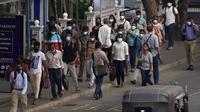 Orang-orang yang memakai masker pulang dari bekerja di Kolombo, Sri Lanka, Kamis, 3 Maret 2022. Perlahan tapi pasti, kehidupan di Asia Selatan kembali normal, dan orang-orang berharap yang terburuk dari pandemi COVID-19 ada di belakang mereka. (AP Photo/Eranga Jayawardena)