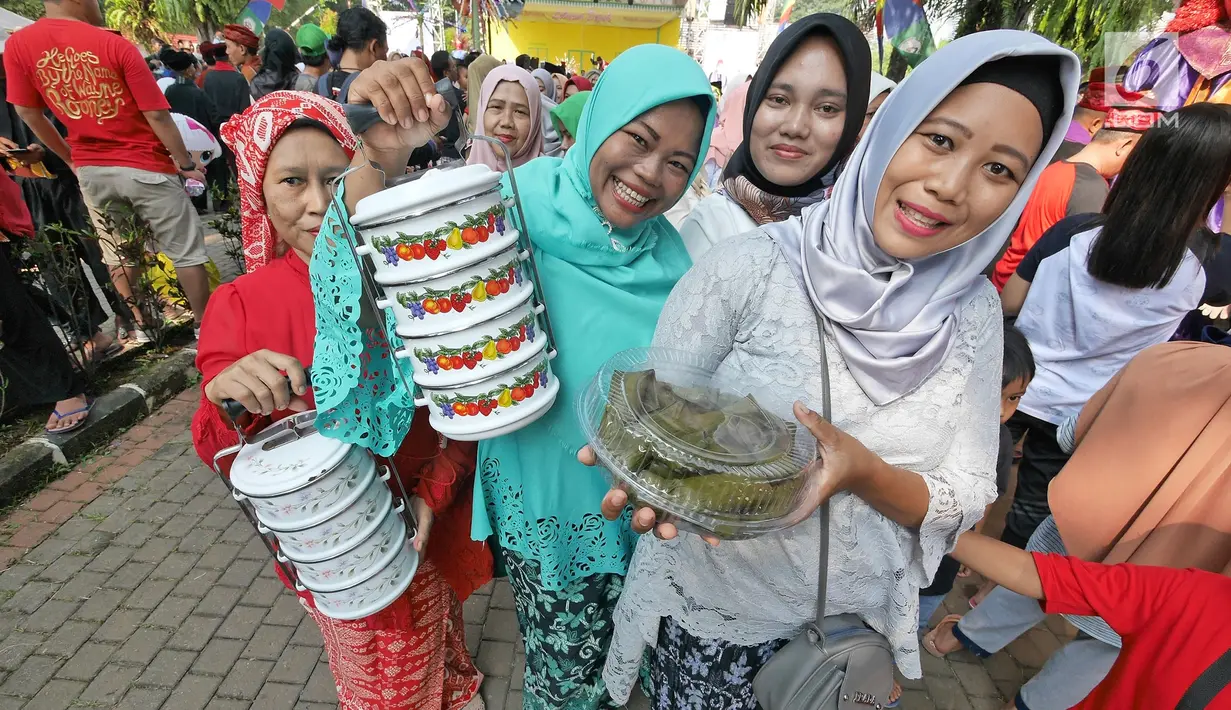 Warga membawa makanan saat pawai pada Lebaran Orang Depok di Sawangan, Depok, Jawa Barat, Minggu (7/7/2019). Lebaran Orang Depok baru pertama kali diadakan acara tersebut untuk melestarrikan budaya dan sebagai ajang silaturahmi warga Depok. (Liputna6.com/Herman Zakharia)