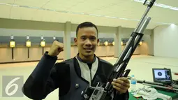Petembak Indonesia, M Hasan Busri mengangkat tangan usai meraih perak 39th South East Asia Shooting Championships kelas 10m Air Rifle Men di Jakarta, Kamis (19/11/2015). Hasan mencatat 200,2poin. (Liputan6.com/Helmi Fithriansyah)