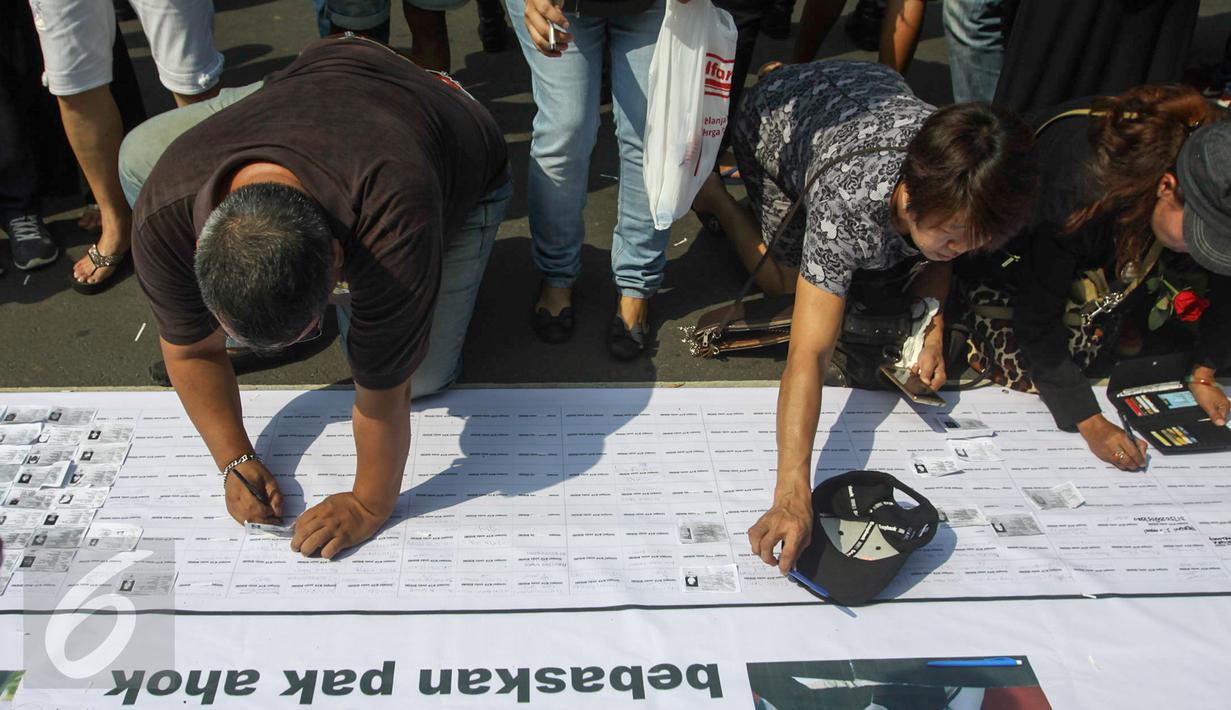 Para pendukung Ahok membubuhkan tandatangan saat aksi di depan Balaikota, Jakarta, Sabtu (13/5). Massa pendukung Ahok menggelar aksi pengumpulan KTP untuk membebaskan Ahok dari jeratan vonis dua tahun penjara. (Liputan6.com/Yoppy Renato)