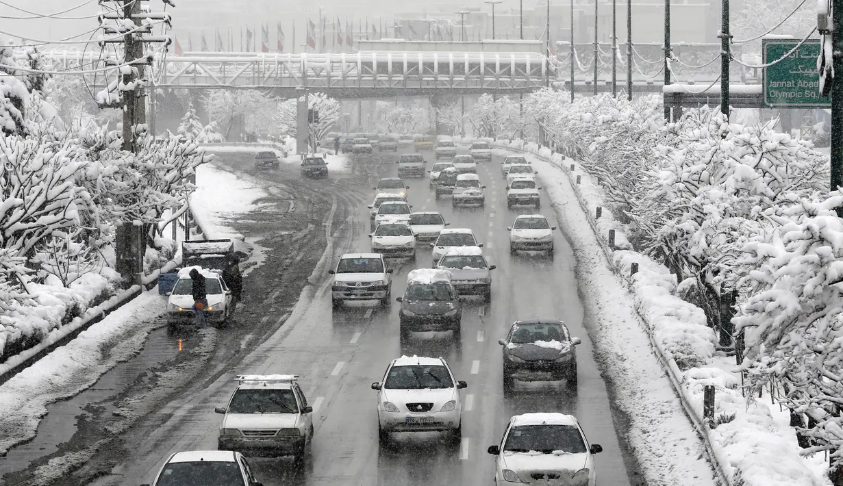 Salju tebal menutupi jalan raya di Ibu Kota Teheran, Iran, Minggu (28/1). Sekitar 20 provinsi di barat dan utara Iran terkena dampak hujan salju yang dimulai pada Kamis dan mencapai puncaknya pada Sabtu malam. (AFP PHOTO/ATTA KENALI)