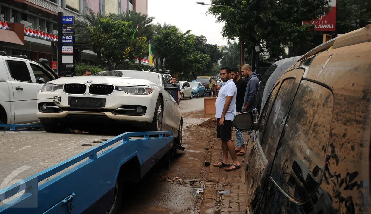 Sebuah mobil mewah dievakuasi setelah terjebak banjir di basement sebuah pertokoan di Jalan Kemang Raya, Minggu (28/8). Sejumlah kendaraan terendam air di kawasan Kemang pasca hujan deras di Jakarta, Sabtu (27/8). (Liputan6.com/Helmi Fithriansyah)