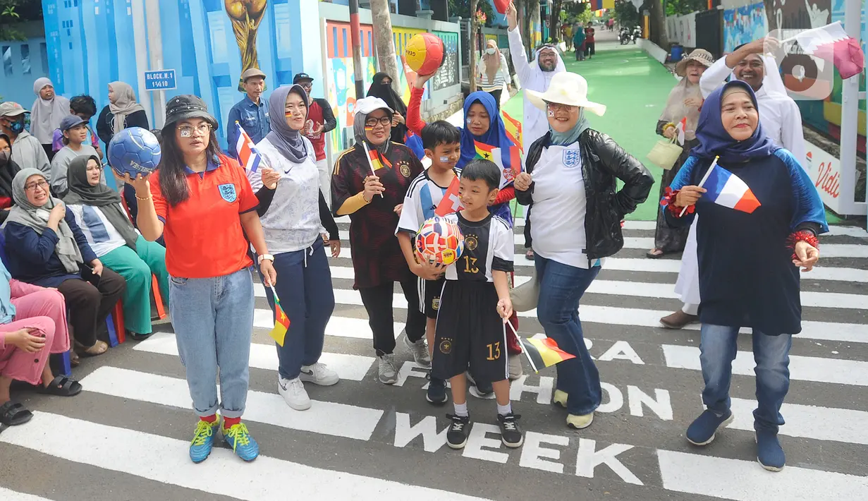 Warga dengan mengenakan jersey atau kostum tim sepak bola peserta Piala Dunia 2022 Qatar menggelar fashion show di Perum Depok Maharaja Blok M1 Cluster Cemara, Rangkapan Jaya, Depok, Minggu (20/11/2022). Fashion show Piala Dunia 2022 diikuti semua kalangan usia dari anak-anak hingga dewasa. (merdeka.com/Arie Basuki)