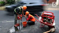 Pekerja mengebor aspal yang menutup sumur resapan di Jalan Lebak Bulus III, Cilandak, Jakarta Selatan, Senin (6/12/2021). Sebanyak 29 sumur resapan yang tertutup aspal kembali dilubangi agar bisa bisa menampung air saat curah hujan tinggi. (merdeka.com/Arie Basuki)