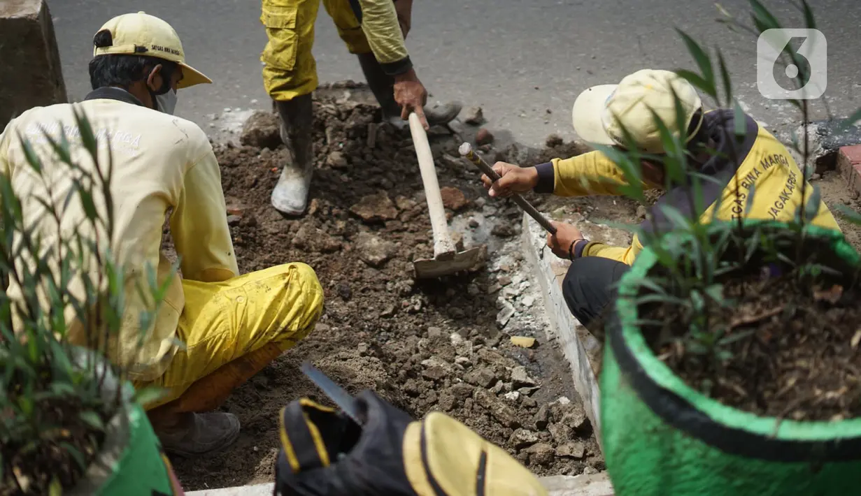 Petugas Bina Marga memerlebar saluran air di Jalan TB Simatupang di kawasan Cilandak, Jakarta, Kamis (22/10/2020). Hal tersebut dilakukan guna memaksimalkan fungsi sistem drainase agar tidak terjadi genangan air saat menghadapi musim hujan. (Liputan6.com/Immanuel Antonius)