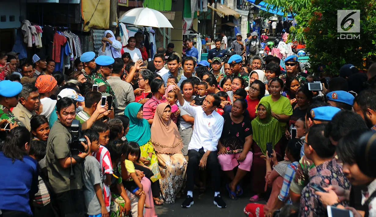 Pasangan Capres Cawapres Joko Widodo (Jokowi)-Ma'ruf Amin menyapa warga usai menyampaikan pidato kemenangannya di Kampung Deret, Jakarta, Selasa (21/5/2019). Pidato itu menanggapi keputusan KPU yang menetapkan pasangan Jokowi Ma'ruf Amin sebagai pemenang Pilpres 2019. (Liputan6.com/Angga Yuniar)