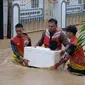 Aparat Polda Sulut dan Basarnas Manado mengevakuasi seorang balita yang terjebak banjir di Manado, Jumat (27/1/2023).