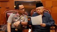 Kapolri Jenderal Pol Tito Karnavian (kiri) bersama Ketua MUI Ma'ruf Amin melihat berkas jelang memberi keterangan di Jakarta, Selasa (20/12). Keterangan terkait fatwa MUI tentang penggunaan atribut keagamaan non-Muslim. (Liputan6.com/Helmi Fithriansyah)