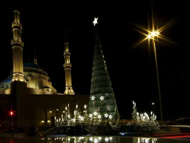 Sebuah pohon Natal raksasa yang dirancang oleh desainer Lebanon, Elie Saab terlihat berdiri di depan Masjid Al-Amin, di pusat kota Beirut, 12 Desember 2015. (REUTERS/Jamal Saidi)