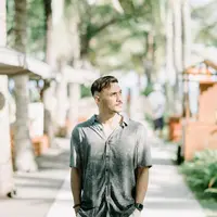 Kombinasi kemeja bermotif warna abu-abu dengan celana putih bisa jadi pilihan menarik buat kamu yang suka gaya simpel. (Instagram/refalhady).