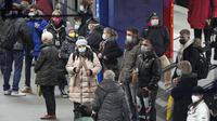Orang-orang mengenakan masker yang menjadi mandat di stasiun kereta bawah tanah di pusat kota Essen, Jerman, Rabu (12/1/2022). Jerman pada Rabu melaporkan lebih dari 80.000 kasus corona covid-19 dalam sehari yang merupakan tertinggi sejak pandemi. (AP Photo/Martin Meissner)