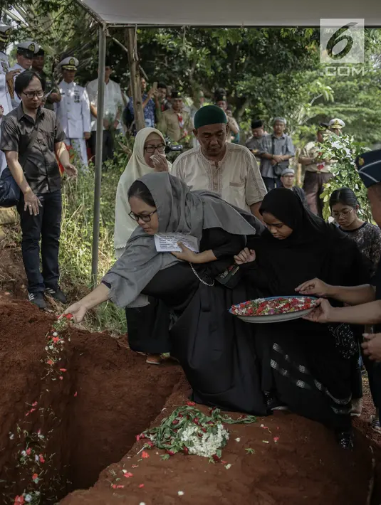 Keluarga dan kerabat menaburkan bunga di makam almarhum Amoroso Katamsi di (TPU) Tanah Wakaf Pondok Labu, Jakarta, Selasa (17/4). Amoroso meninggal pada Selasa 17 April 2018 pukul 01.40 dini hari pada usia 79 tahun. (Liputan6.com/Faizal Fanani)