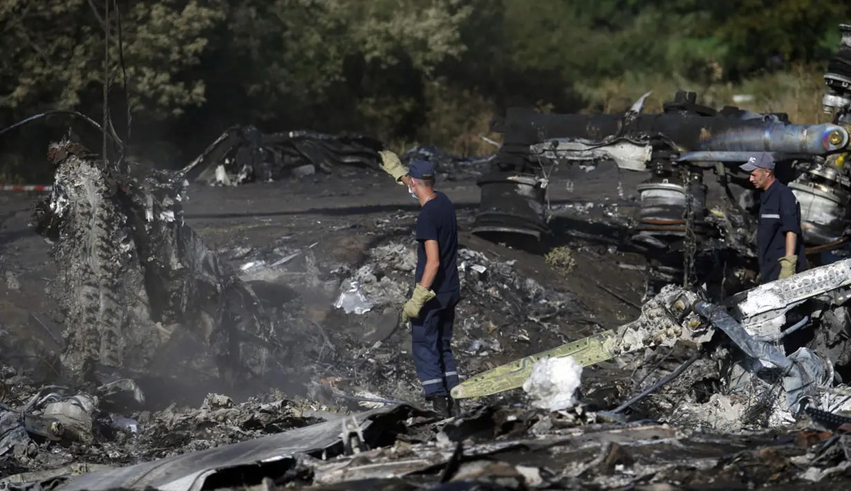 Anggota Kementerian Darurat Ukraina mencari bukti baru jatuhnya pesawat Malaysia Airlines MH-17 diantara sisa puing-puing di desa Hrabove, Donetsk, Ukraina, (20/7/2014). (REUTERS/Maxim Zmeyev)