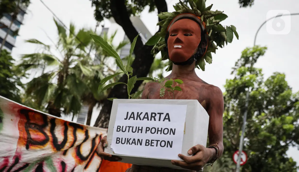 Aktivis Walhi membawa pohon saat menggelar aksi terkait proyek revitalisasi kawasan Monas di depan Balai Kota DKI Jakarta, Kamis (30/1/2020). Selain minta dihentikan, mereka juga mendesak kawasan Monas dikembalikan ke fungsi awal sebagai ruang terbuka hijau (RTH). (Liputan6.com/Faizal Fanani)