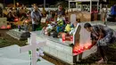 Seorang wanita menaruh lilin di makam keluarganya yang berada di pemakaman Cayenne di Guyana Prancis (1/11). All Saints Day disebut juga Hari Raya Semua Orang Kudus, dan digelar setiap tanggal 1 November. (AFP Photo/Jody Amiet)