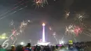 Kembang api menghiasi langit di kawasan Monas, Jakarta, Jumat (1/1). Antusiasme warga yang memadati Monas saat malam pergantian tahun membuat langit di kawasan tersebut dimeriahkan dengan pesta kembang api. (Liputan6.com/Immanuel Antonius)