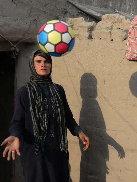 Foto pada 20 Maret 2018, perempuan Afghanistan Sitara Wafadar yang menyamar sebagai laki-laki bermain bola di rumahnya, Provinsi Nangarhar. Tradisi "bacha pochi" sudah mengakar di Afghanistan yang lebih menghargai anak laki-laki. (NOORULLAH SHIRZADA/AFP)