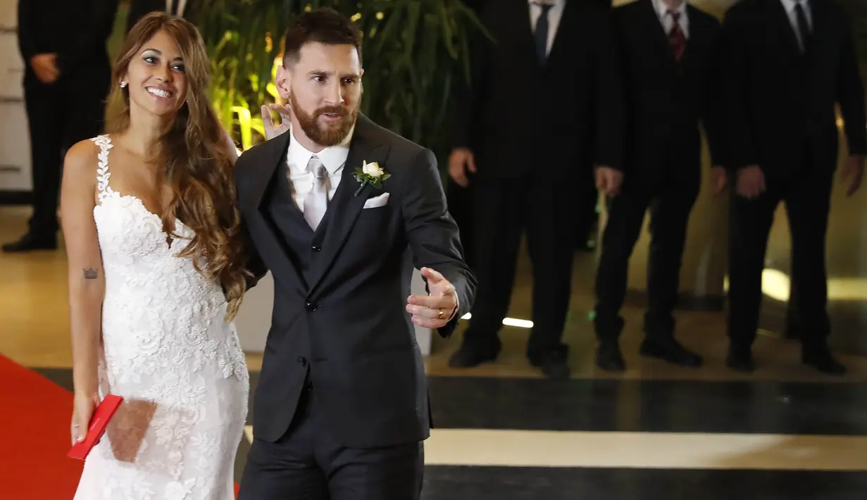 Bintang Barcelona, Lionel Messi, didampingi sang istri, Antonella Ruccozzo, menyapa wartawan usai mengadakan resepsi pernikahan di Kompleks City Center, Santa Fe, Jumat (30/6/2017). (EPA/David Fernandez)