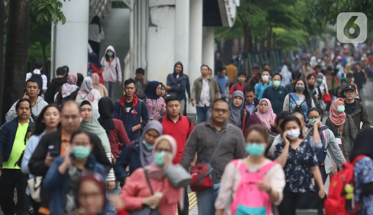 Pekerja berjalan kaki saat jam pulang di kawasan Sudirman, Jakarta, Jumat (7/2/2020). BPJS Ketenagakerjaan yang kini bernama BP Jamsostek menargetkan sekitar 23,5 juta tenaga kerja baru masuk dalam daftar kepesertaan pada 2020. (Liputan6.com/Angga Yuniar)