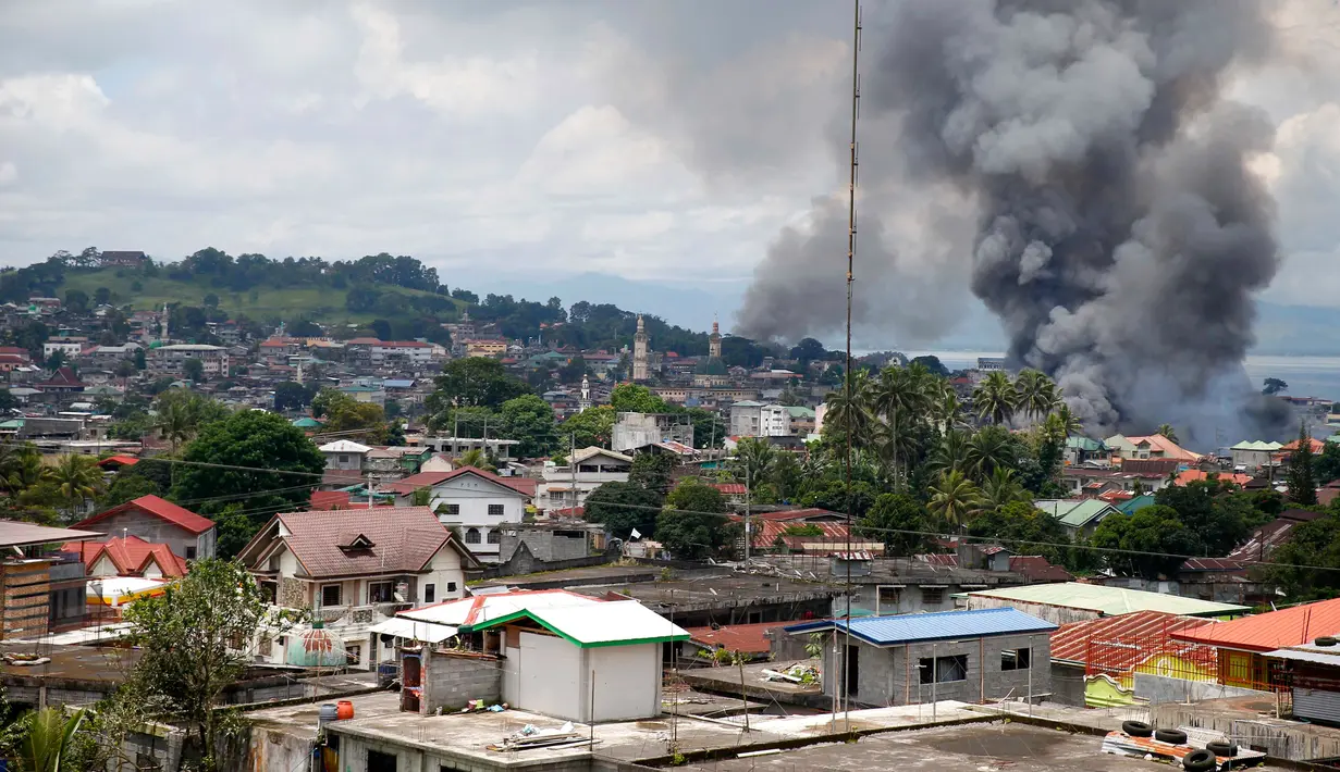 Asap hitam membumbung tinggi ke udara usai militer pemerintah Filipina melancarkan serangan udara ke sebuah lokasi yang telah dikuasai oleh militan Maute di kota Marawi, Filipina Selatan, (27/5). (AP Photo / Bullit Marquez)
