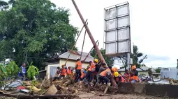 Pekerja memperbaiki tiang listrik di daerah yang terkena banjir bandang di Waiwerang, Pulau Adonara, Nusa Tenggara Timur, Selasa (6/4/2021). Tim penyelamat terus menggali puing tanah longsor untuk mencari korban yang terkubur usai bencana banjir bandang. (AP Photo/Rofinus Monteiro)