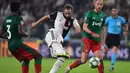 Penyerang Juventus, Gonzalo Higuain  (tengah) menendang bola dari kawalan dua pemain Lokomotiv Moscow pada pertandingan lanjutan grup D Liga Champions di Stadion Allianz, Turin, Italia (22/10/2019). menang tipis atas Lokomotiv Moscow 2-1. (Miguel Medina/AFP)