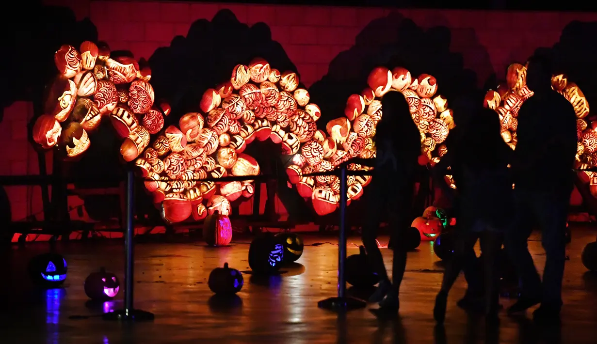 Pengunjung menikmati labu yang disusun menjadi bentuk naga yang dipamerkan dalam malam Festival Halloween di Los Angeles, California (16/10). Halloween dirayakan setiap tahun pada tanggal 31 Oktober. (AFP/Mark Ralston)