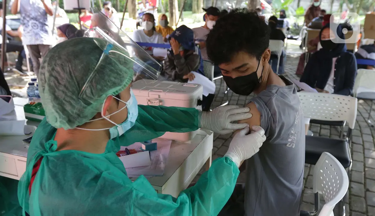 Vaksinator menyuntikkan vaksin COVID-19 untuk warga di Taman Dadap Merah, Kebagusan, Jakarta, Sabtu (10/7/2021).  Pelaksanaan vaksinasi melalui mobil vaksin keliling juga diperuntukkan untuk anak usia 12 tahun ke atas. (Liputan6.com/Helmi Fithriansyah)